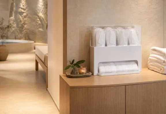 Dispenser ordinato con ciabatte monouso bianche in uno spogliatoio di SPA d’hotel.