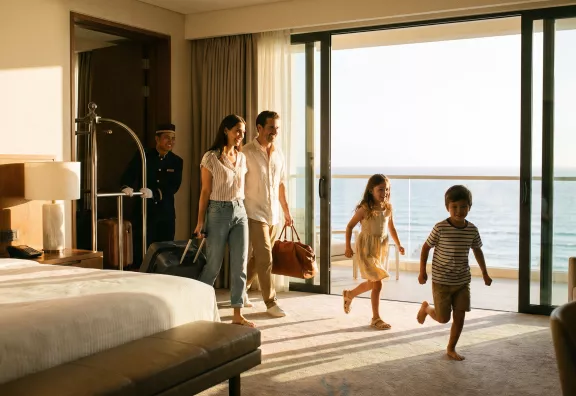 famiglia-che-entra-nella-stanza-di-un-hotel-con-valigie-in-mano