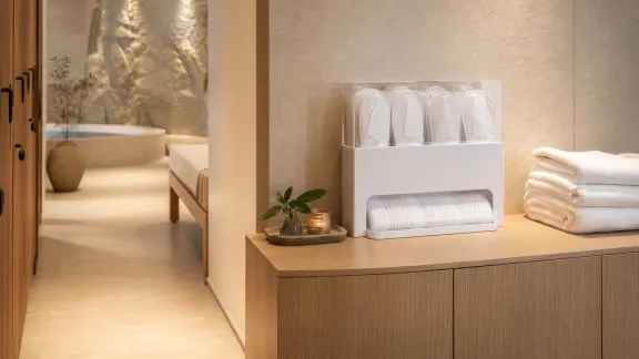 Dispenser ordinato con ciabatte monouso bianche in uno spogliatoio di SPA d’hotel.